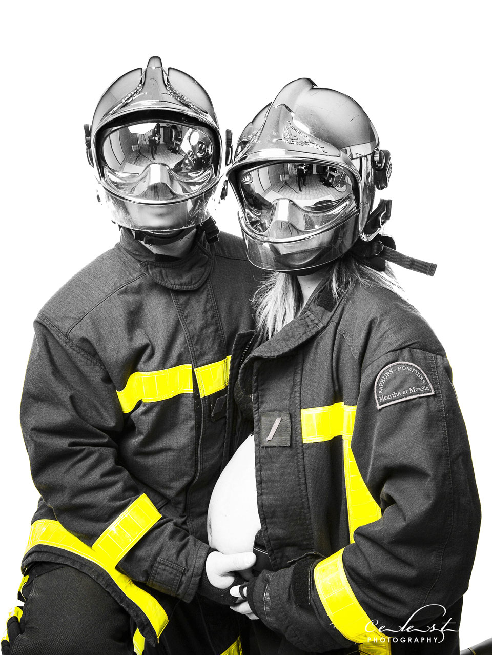 couple de pompiers vêtus de leurs casques visières fermés et vestent laissent apparaitre le ventre d'une femme enceinte