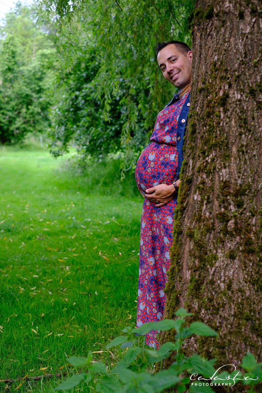 femme enceinte caché derrière un arbre laisse apparaître une tête d'homme