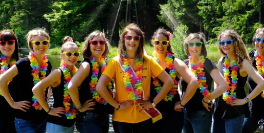 groupe de jeunes femmes aux lunettes de soleil colorés posant avec la future mariée au milieu